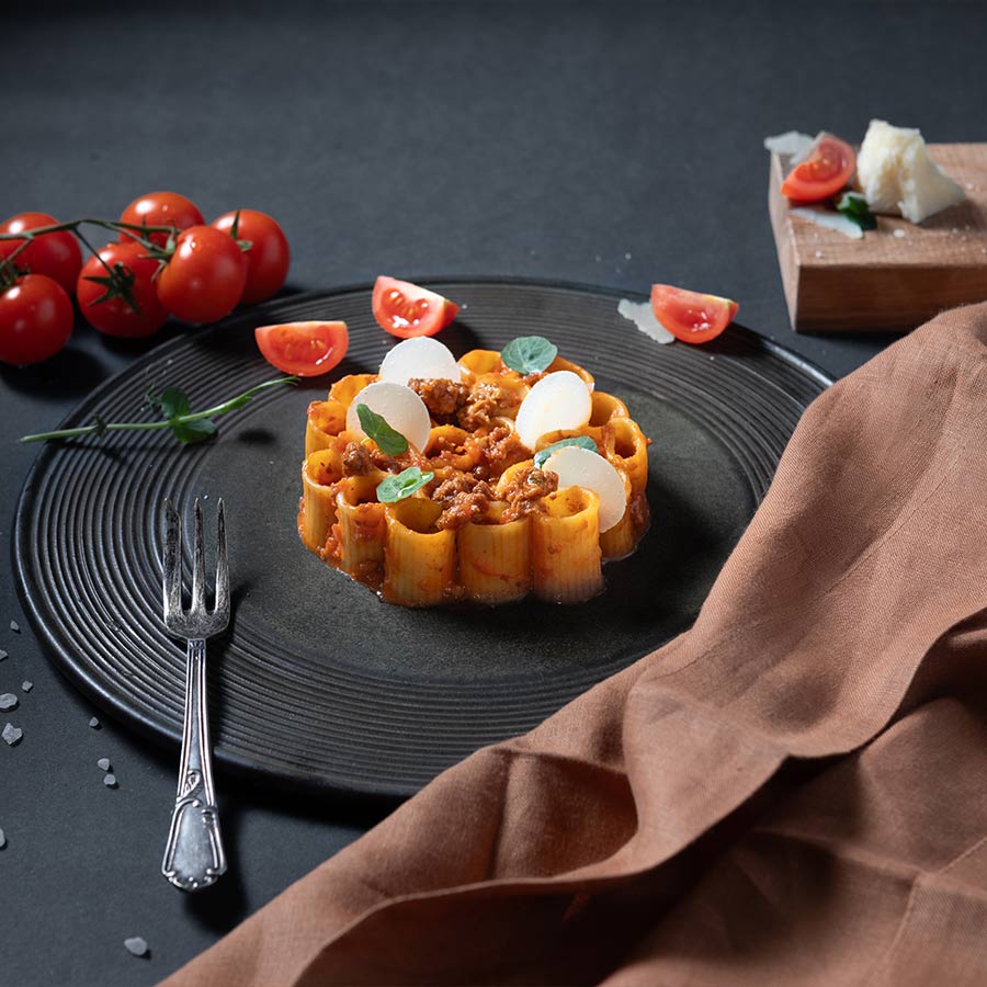 Piatto di cannelloni ripieni di carne e formaggio, serviti su un piatto bianco